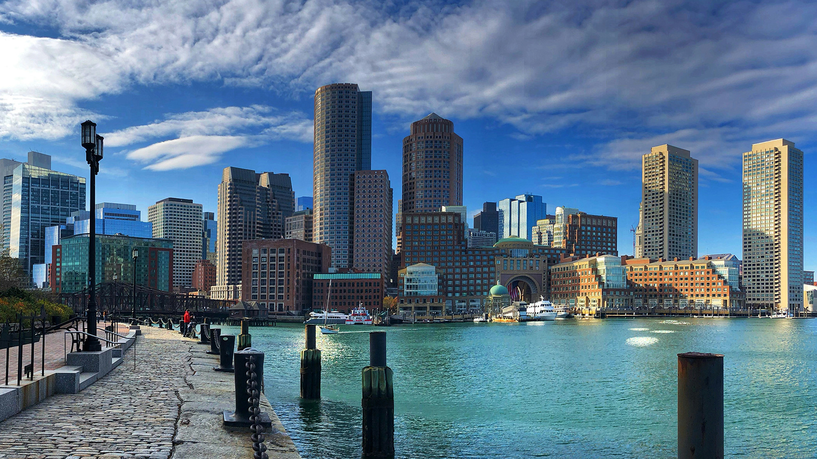 Skyline of Boston with a harbor in the foreground.