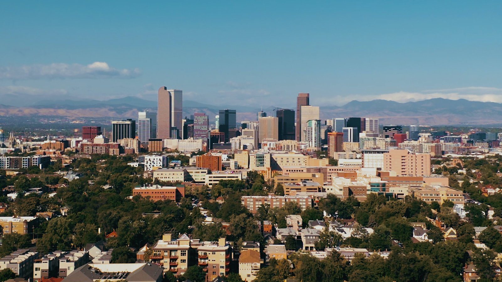 An image of downtown Denver with the Rocky Mountains in the background.