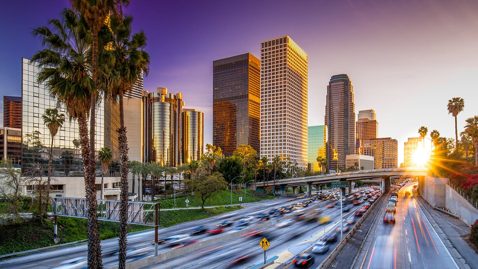 Los Angeles downtown skyline behind highway during sunset