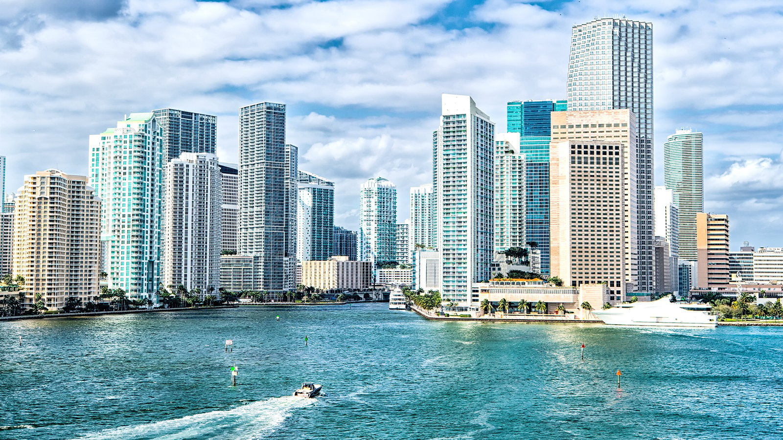 The Miami skyline with a speed boat driving in the lower foreground.