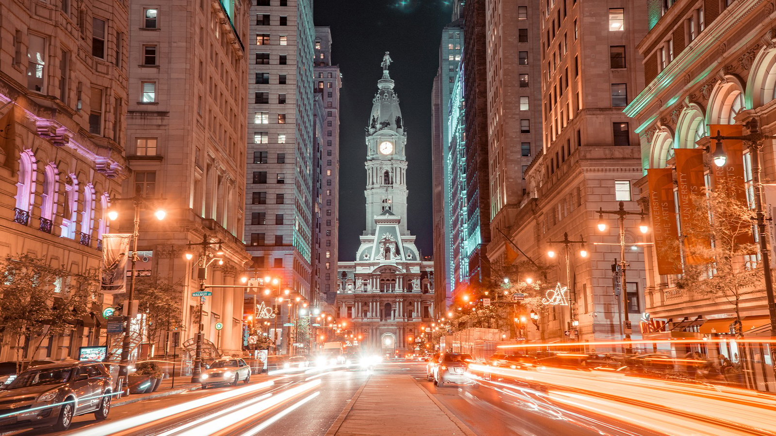 A time lapsed image of Philadelphia with cars passing in front of City Hall.