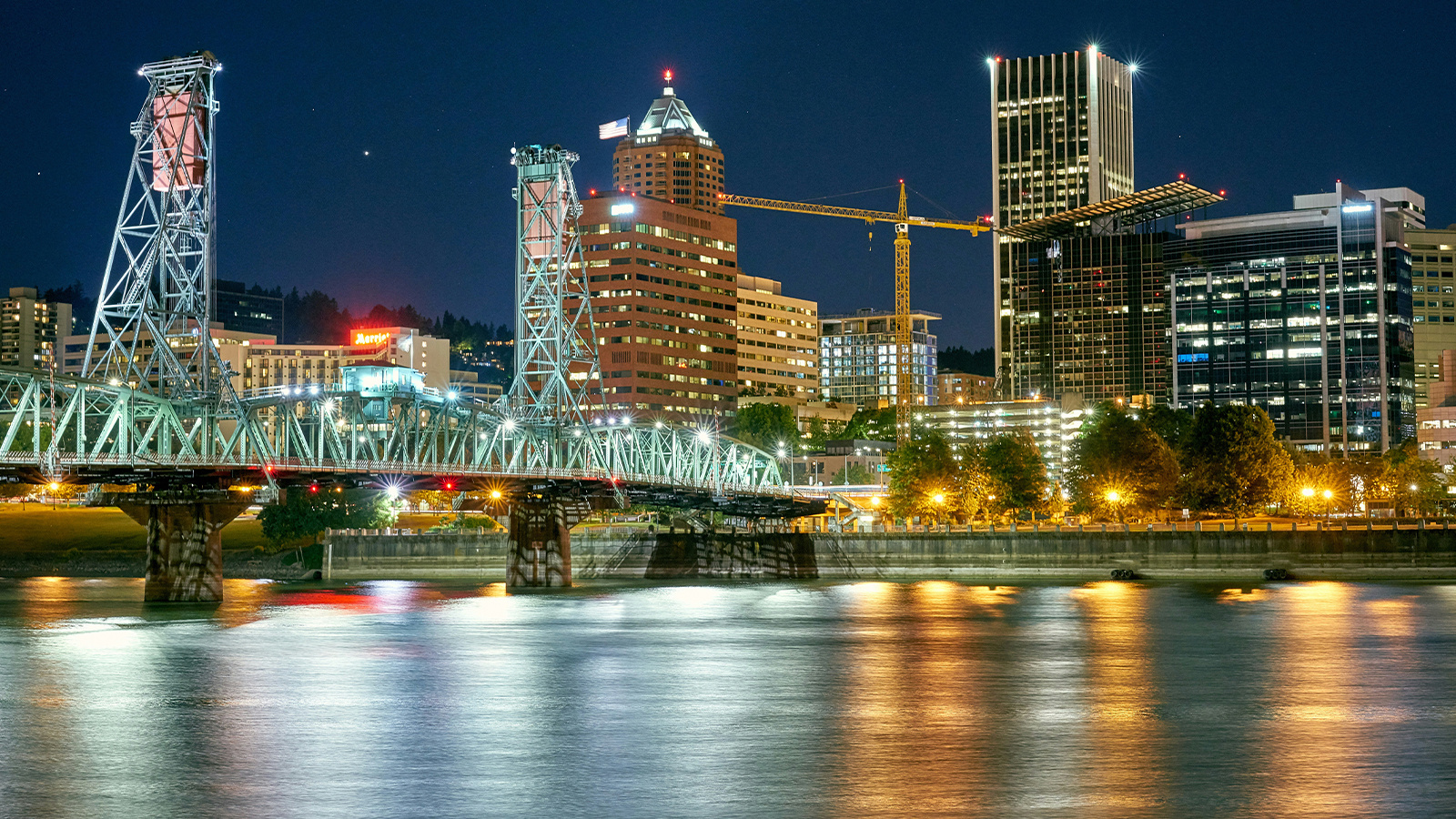 Portland Oregon skyline at night with a river in the foreground