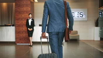 A business traveler in a suit arriving at a hotel for check-in.