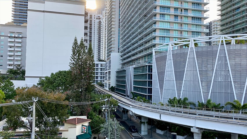 Modern elevated transit system or monorail track curving through Miami's urban landscape with high-rise buildings.