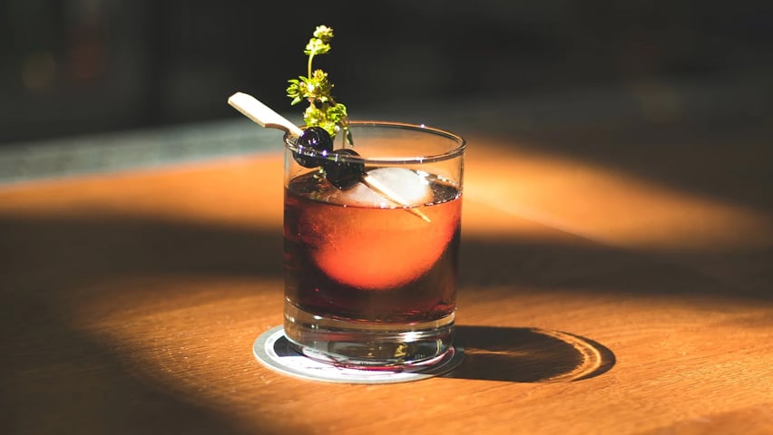 An image of a cocktail sitting on a wooden table.