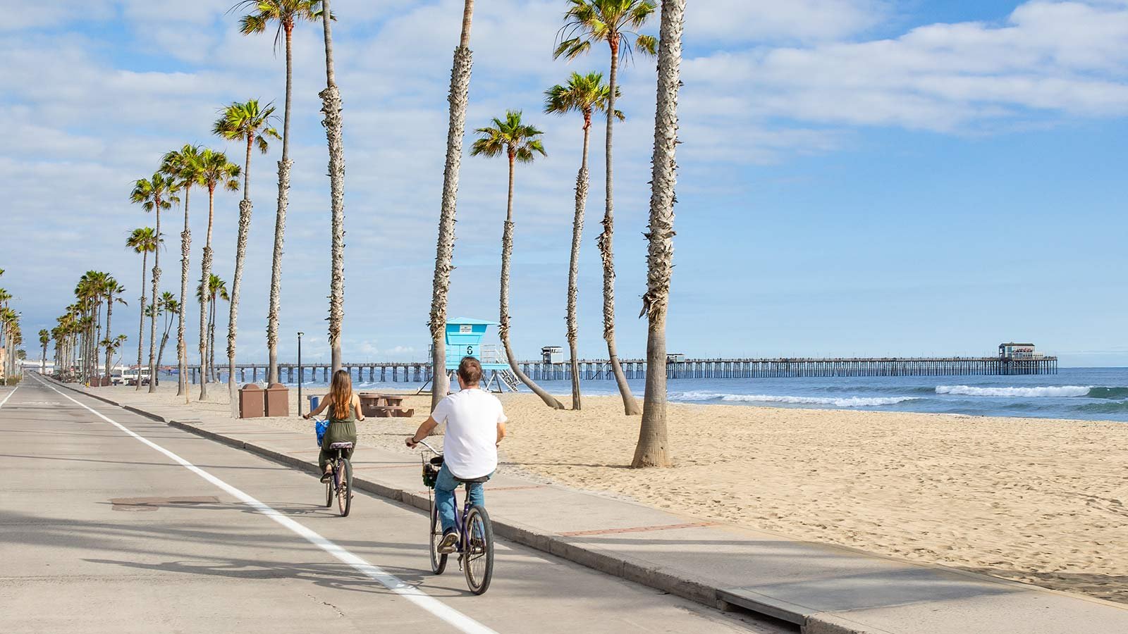 People riding bikes along the San Diego beach