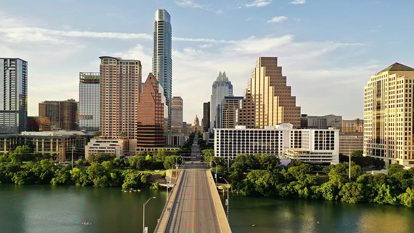 Downtown Austin skyline viewed from across Lady Bird Lake during golden hour lighting.