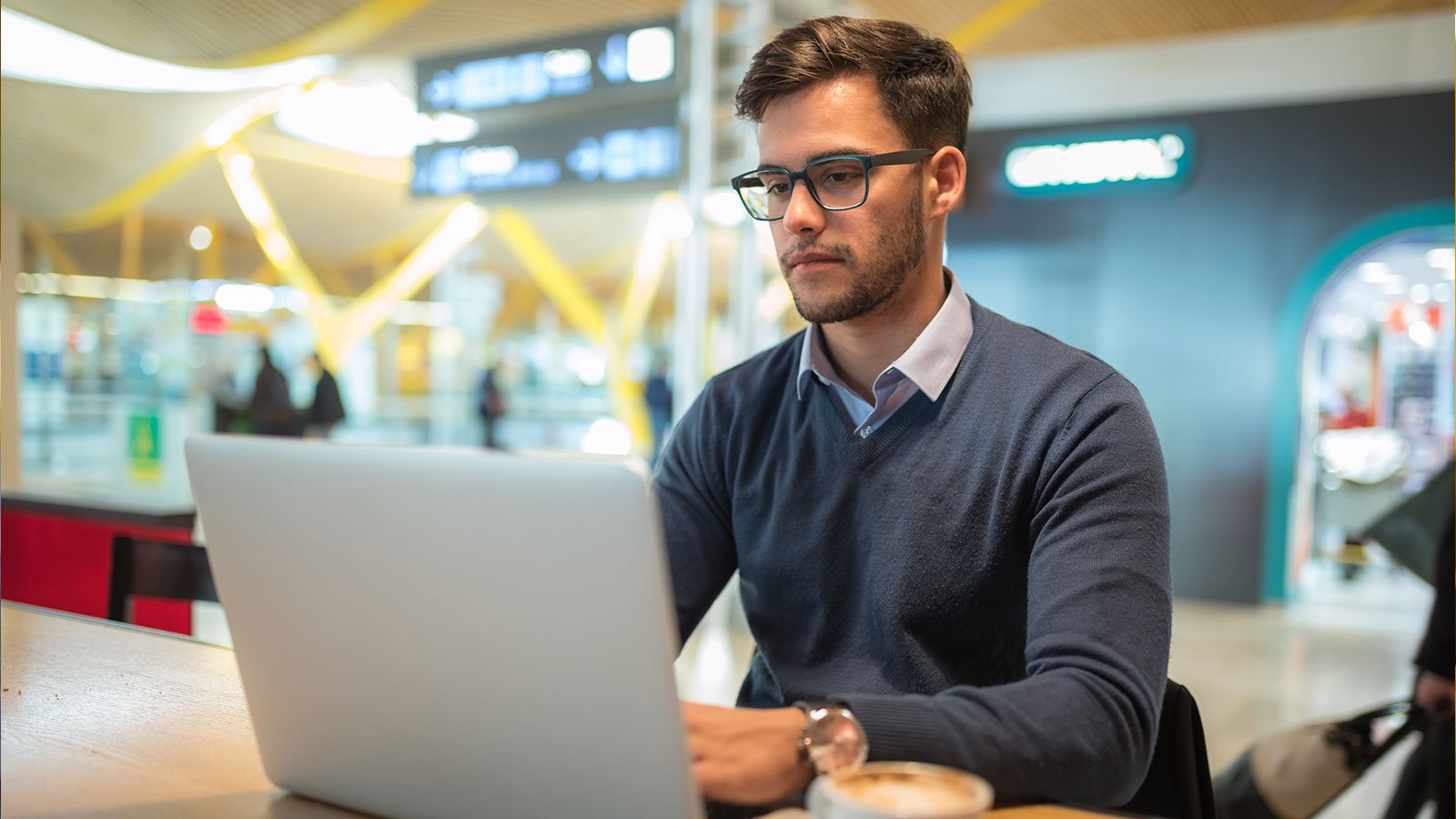 business man working with laptop using his mobile phone and drinking coffee