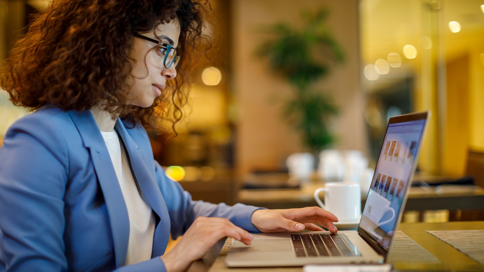Businesswoman working on laptop at hotel cafe